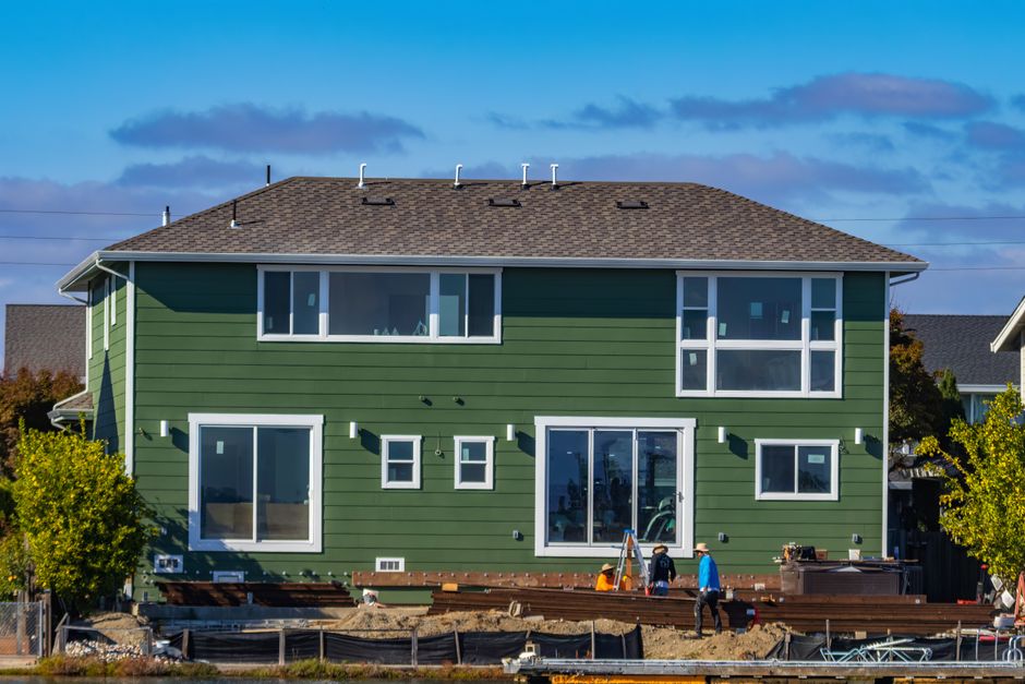 Contractors installing durable vinyl house siding